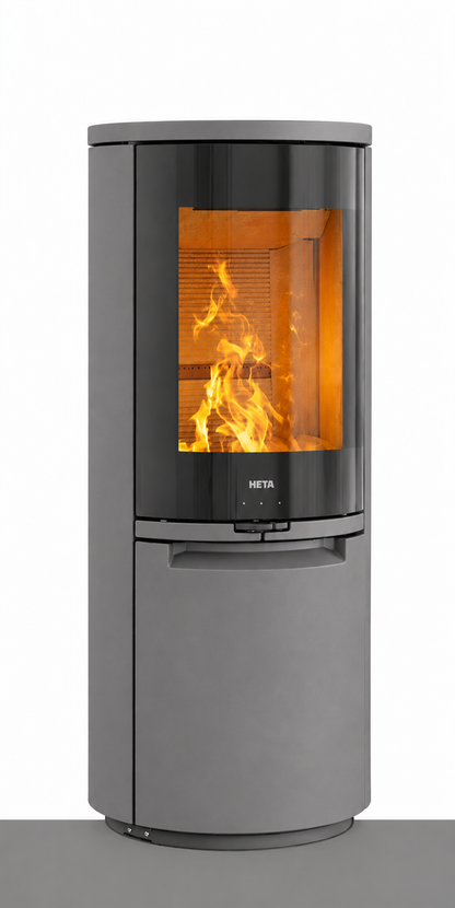 A modern cylindrical wood-burning stove with a dark glass front showing bright orange flames, set against a plain white background.
